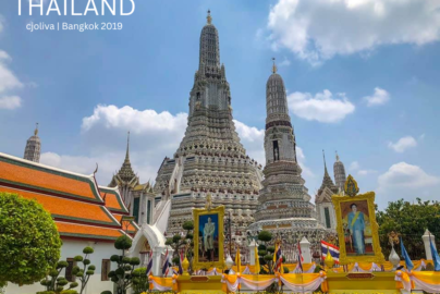 The white porcelain prangs of Wat Arun temple against a blue sky in Bangkok.