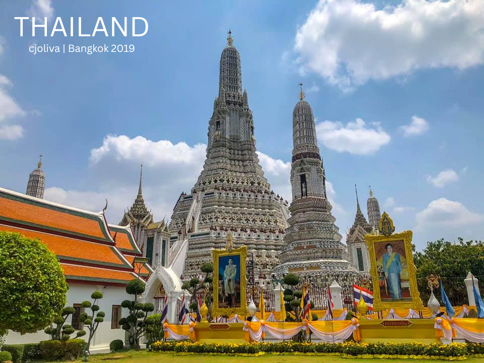 The white porcelain prangs of Wat Arun temple against a blue sky in Bangkok.