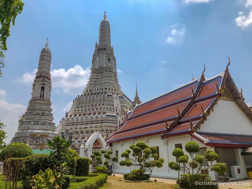 Wat Arun Temple of Dawn in Bangkok with ornate prangs and gardens under a bright sky