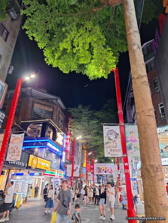Bustling Ximending night market street in Taipei with neon signs and crowds