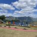Scenic outdoor view of Montevalle with large colorful letters spelling "I Love Montevalle," including a strawberry shape, surrounded by green hills and mountains under a partly cloudy blue sky.