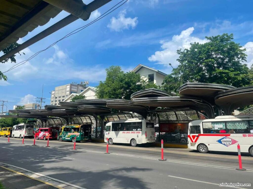 Modern bus terminal and transport hub in Cebu City with buses and jeepneys lined up under covered platforms on a sunny day