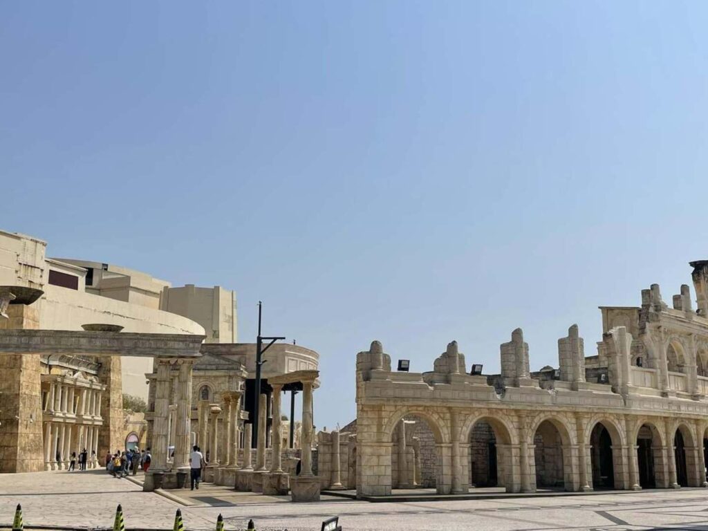 Solo travel in Asia: Classical Roman-style stone arches and columns at Macau Fisherman's Wharf under a clear blue sky.