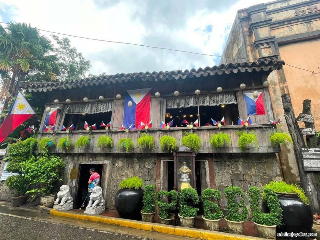 Exterior of Yap-Sandiego Ancestral House with Philippine flags and greenery