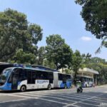 The Blue TransJakarta articulated bus stopped at Monumen Nasional station for solo backpacking in Jakarta, Indonesia.