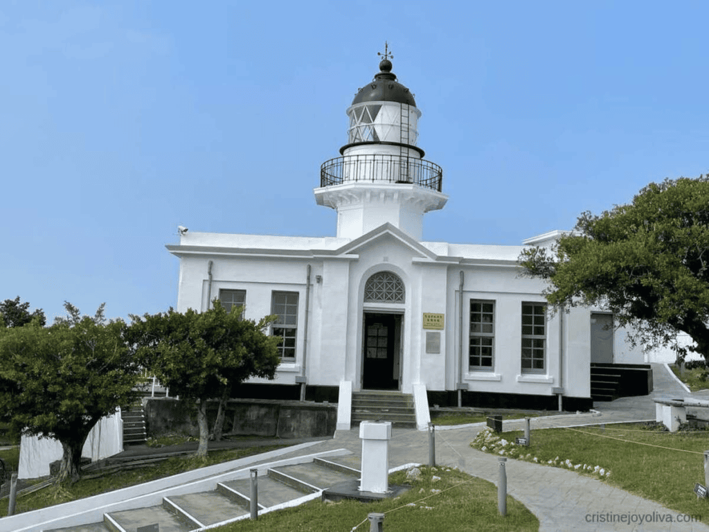 The historic Kaohsiung Lighthouse on Cijin Island, a stunning white lighthouse and museum against a clear blue sky, is a popular landmark for visitors in Kaohsiung, Taiwan.
