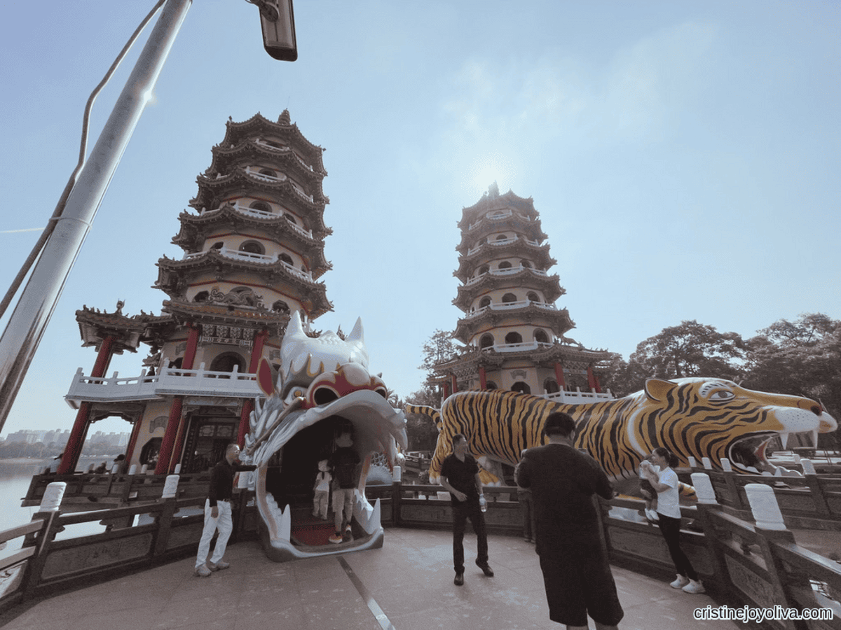 Visitors enter through the open mouth of the large dragon statue in front of the Twin Dragon and Tiger Pagodas at Lotus Pond in Kaohsiung, Taiwan.