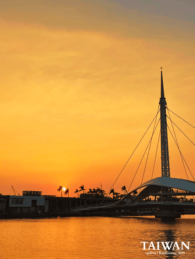 Golden sunset sky illuminating the white cable-stayed Great Harbor Bridge in Kaohsiung.