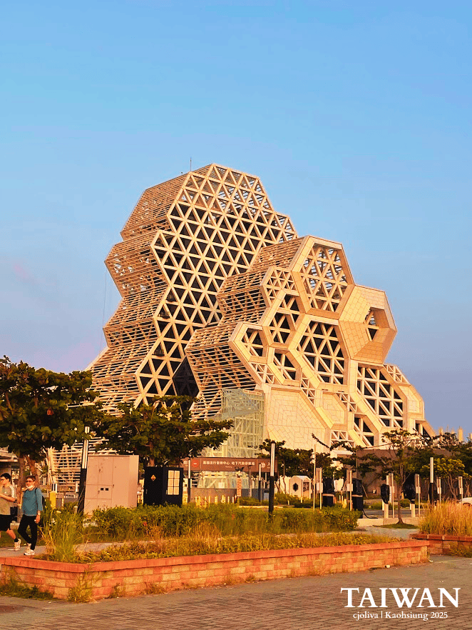 Geometric honeycomb lattice design of the Kaohsiung Music Center glowing in warm sunset light.