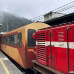 Alishan Forest Railway train at Fenqihu Station, red locomotive and carriages before the Fenqihu to Chiayi ride
