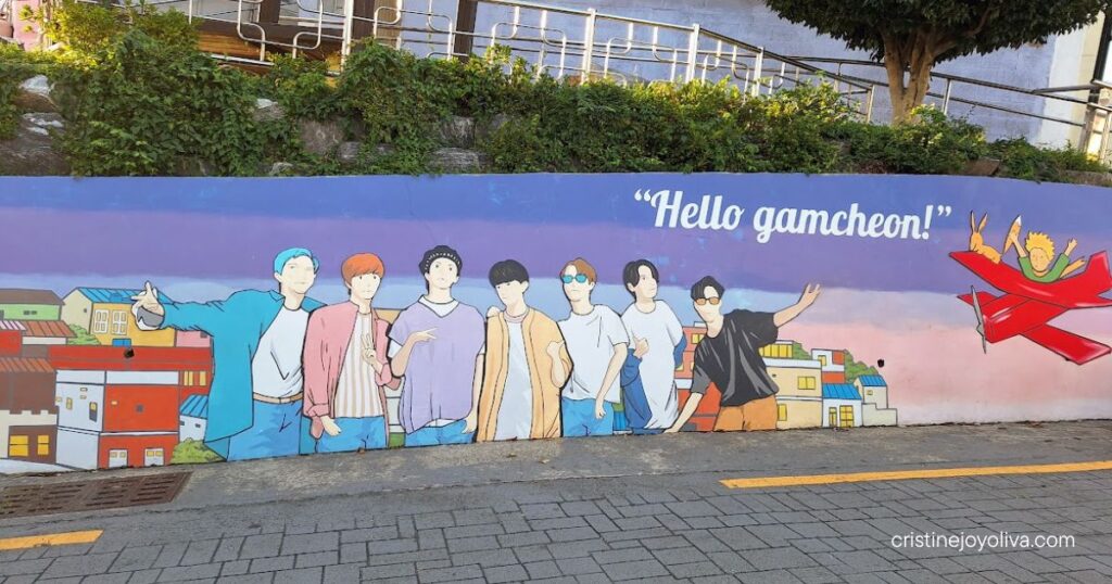 The famous BTS mural in Gamcheon Culture Village along a sloped street during a Busan one-day itinerary.