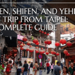 A view of the bustling, lantern-lined narrow streets of Jiufen, Taiwan, on a three-stop day trip from Taipei, featuring a guide map icon.