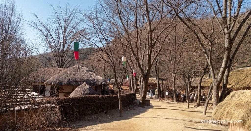 Dirt pathway lined with traditional hanok buildings at Korean Folk Village Yongin.
