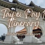 The grand white entrance arch of Liberty Square with blue tiled roofs in Taipei under an overcast sky.