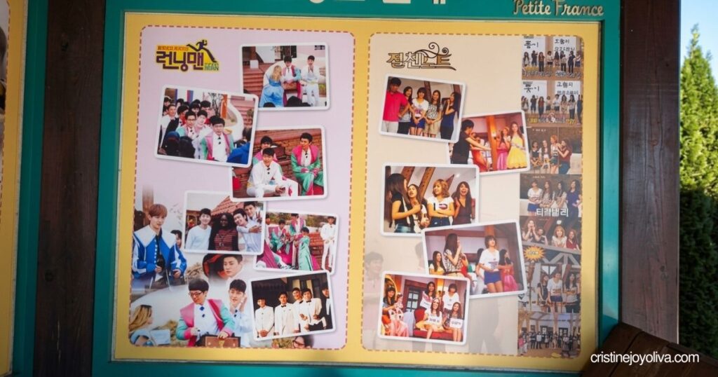 An information board displays photos of South Korean variety shows, including Running Man, filmed at Petite France.