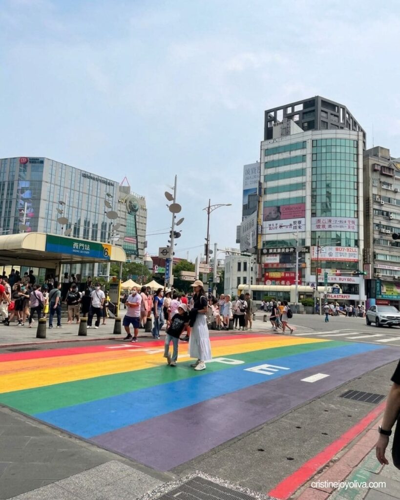 Pedestrians walk across the painted rainbow crosswalk outside Ximen Station in Taipei.