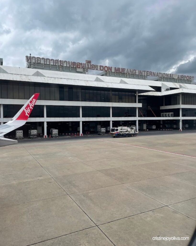 AirAsia wing and the Don Mueang International Airport terminal seen from the plane window on arrival