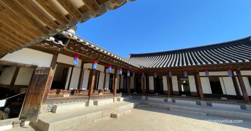 Traditional hanok courtyard with a curved tiled roof and wooden eaves at Namsangol Hanok Village in Seoul