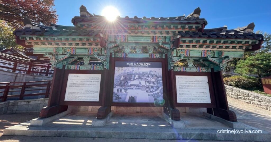 Information map of the pavilion with a colorful traditional roof at Namsangol Hanok Village on a sunny autumn day