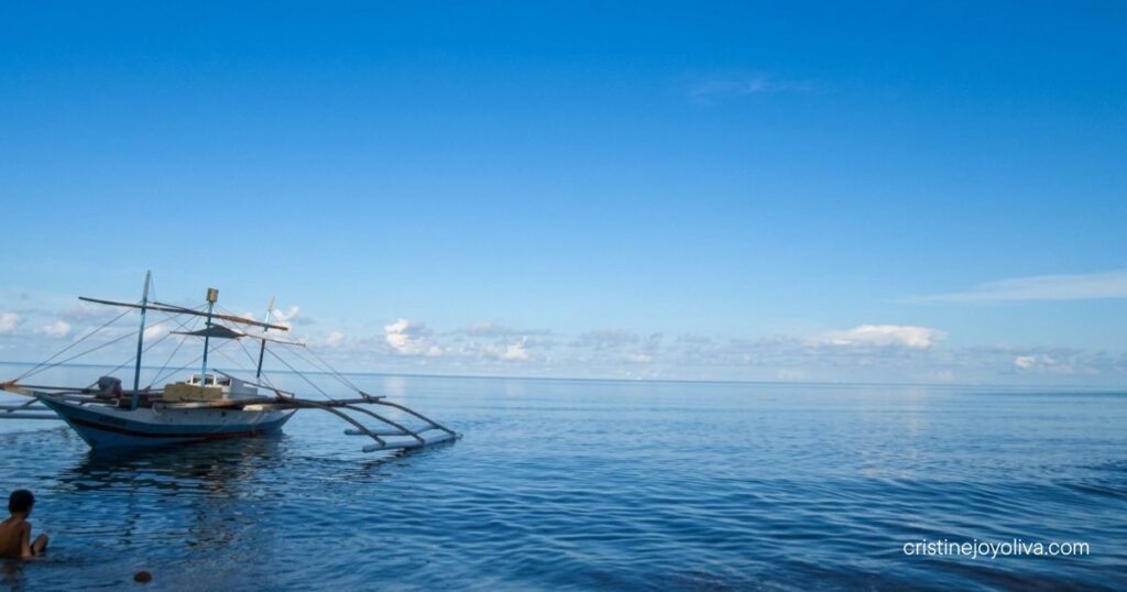 Traditional Filipino bangka boat floating on calm blue waters in Antique, Philippines.