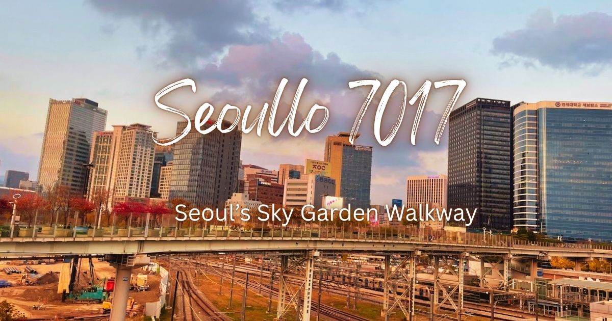 View of Seoul Station railway tracks from Seoullo 7017 with city skyscrapers and autumn trees under a cloudy dusk sky